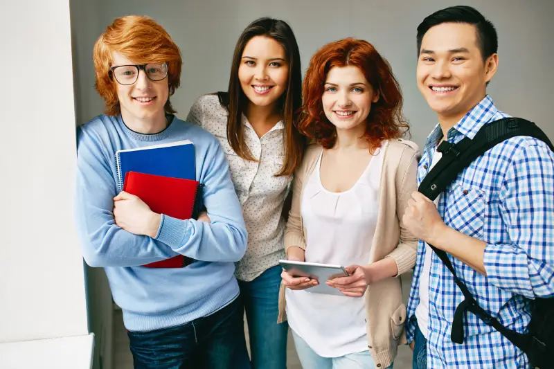 ACADEMICS Portrait of happy college friends looking at camera with smiles